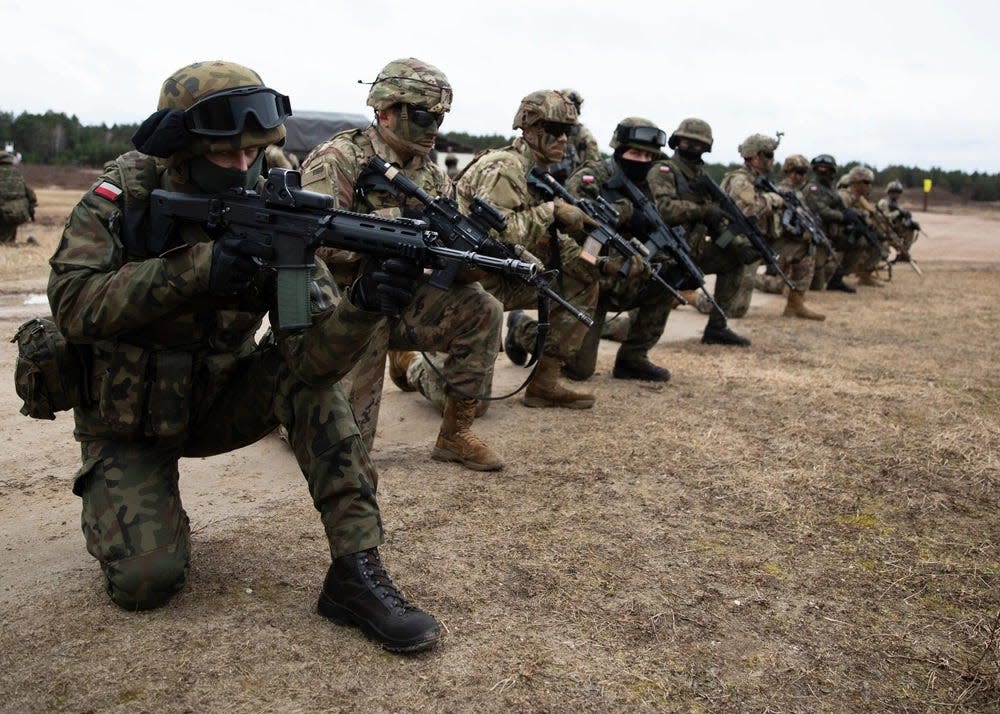 Polish soldiers assigned to the 21st Rifle Brigade and paratroopers assigned to the 3rd Brigade Combat Team, 82nd Airborne Division wait to load a CH-47 Chinook helicopter during a multi-national training event Feb. 25, 2022, in Nowa Deba, Poland.