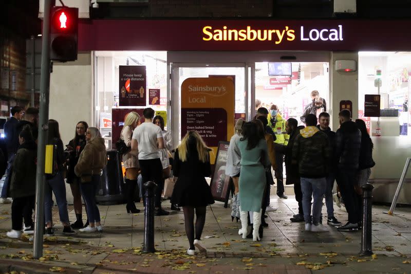 People wait outside a Sainsbury's the night before a local lockdown amidst the spread of the coronavirus disease (COVID-19) in Manchester