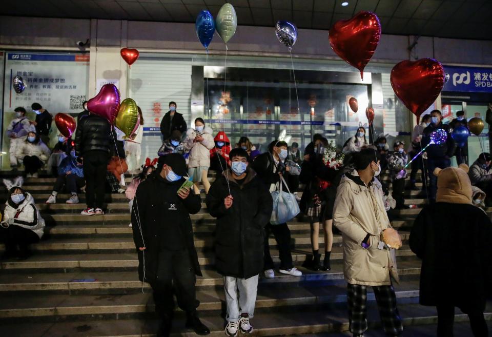 People hold balloons as they gather to celebrate the arrival of the new year in Wuhan (Reuters)