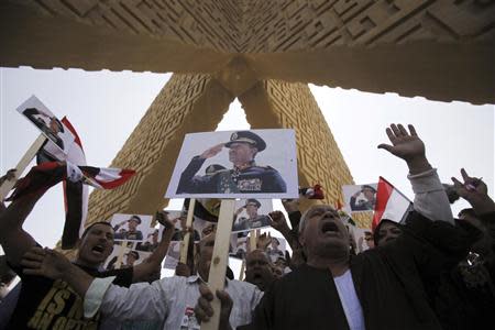 Supporters of the army hold posters of late Egyptian President Sadat as they protest against ousted Islamist President Mursi and members of the Muslim Brotherhood in Cairo