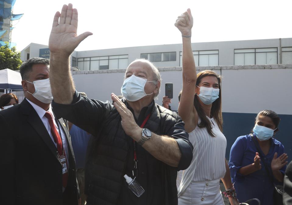 Avanza Pais party presidential candidate Hernando De Soto and his wife Carla Olivieri, wave to supporters upon their arrival to vote during general elections in Lima, Peru, Sunday, April 11, 2021. (AP Photo/Martin Mejia)