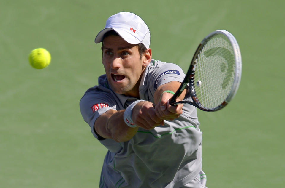 Novak Djokovic, of Serbia, returns a shot to John Isner during their semifinal at the BNP Paribas Open tennis tournament, Saturday, March 15, 2014, in Indian Wells, Calif. Djokovic won 7-5, 6-7 (2), 6-1. (AP Photo/Mark J. Terrill)