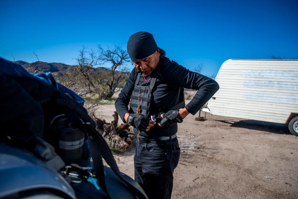 Wendsler Nosie puts on his bullet-proof vest before driving around the area at Oak Flat on Friday, Dec. 20, 2019.