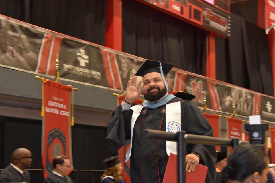 Stephen Billiot waves to his family after receiving his Master of Arts degree from Nicholls State University during the 112th graduation commencement ceremony.