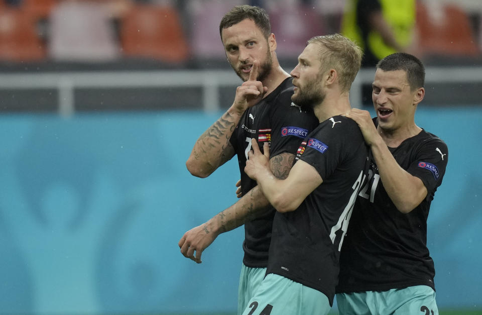 Austria's Marko Arnautovic, left, celebrates with teammates after scoring his side's third goal during the Euro 2020 soccer championship group C match between Austria and Northern Macedonia at the National Arena stadium in Bucharest, Romania, Sunday, June 13, 2021. (AP Photo/Vadim Ghirda, Pool)