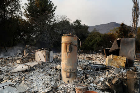 A water heater stands amidst remains of a home destroyed by the Nuns Fire along Napa Road in Sonoma, California, U.S., October 9, 2017. REUTERS/Stephen Lam