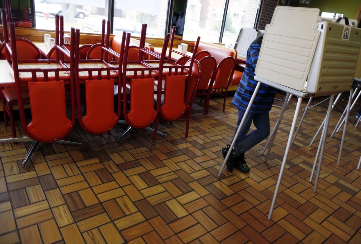 A voter stands in a voting booth to cast his ballot for the U.S. midterm elections at a restaurant used as a polling station in Chicago, Illinois, November 4, 2014. REUTERS/Jim Young (UNITED STATES - Tags: POLITICS ELECTIONS)