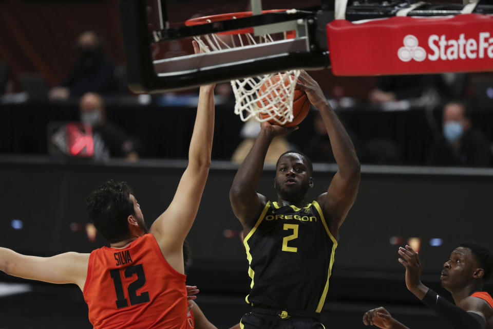 Oregon State's Roman Silva (12) tries to block a shot by Oregon's Eugene Omoruyi (2) during the second half of an NCAA college basketball game in Corvallis, Ore., Sunday, March 7, 2021. (AP Photo/Amanda Loman)