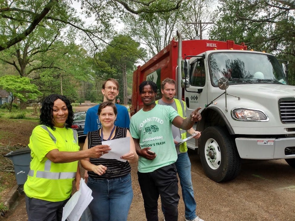 Crews from Richard’s Disposal, Inc. were out in force Monday morning collecting signatures from Jackson residents petitioning city officials to settle the political impasse over the city’s garbage contract. Richard’s employee Barbara Ford (left) collects a signature from Meadow Heights Drive resident Wendy Cooper (second from left) and her husband Rob (in back). Also pictured are Robert’s employees Christopher Jones (fourth from left) and Kenneth Cox (right).