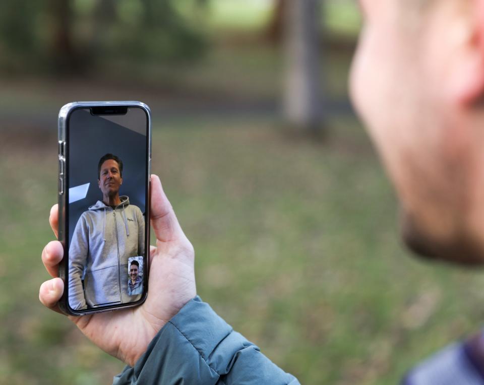 Kevin Peña platica con su papá, Javier Gómez Espana, por medio de FaceTime en el Bush's Pasture Park en Salem, Oregón, el martes 1 de febrero de 2022. Peña pudo localizar a su padre biológico tras hacerse una prueba de 23andMe.