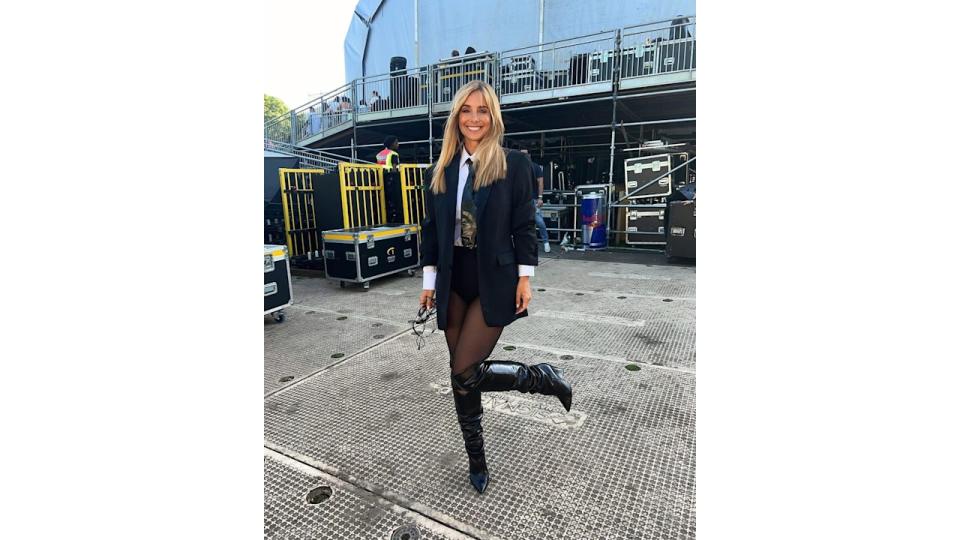 woman posing in blazer, sheer tights and leather boots 