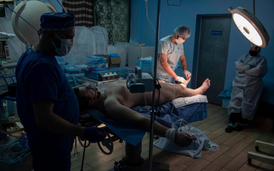 Surgery takes place on a soldier with shrapnel wounds in this left leg at a hospital in the Kharkiv region - JULIAN SIMMONDS for The Telegraph/JULIAN SIMMONDS for The Telegraph