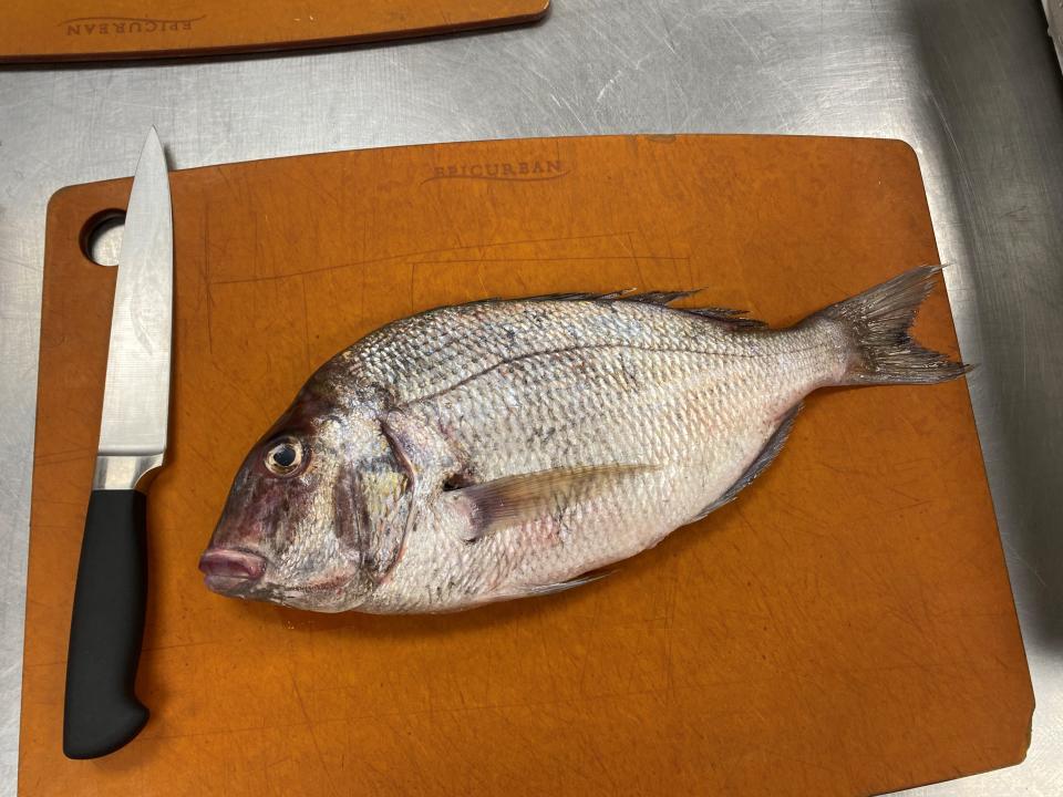 Scup on a cutting board. Many fishmongers will scale and gut the fish for you.