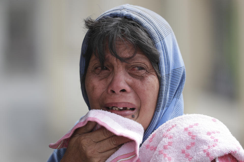 In this Monday, Jan. 13, 2020, photo, Erman Batan breaks in tears over her missing husband Roberto who she has not seen since they evacuated their homes near the Taal volcano in Tagaytay, Cavite province, southern Philippines. (AP Photo/Aaron Favila)