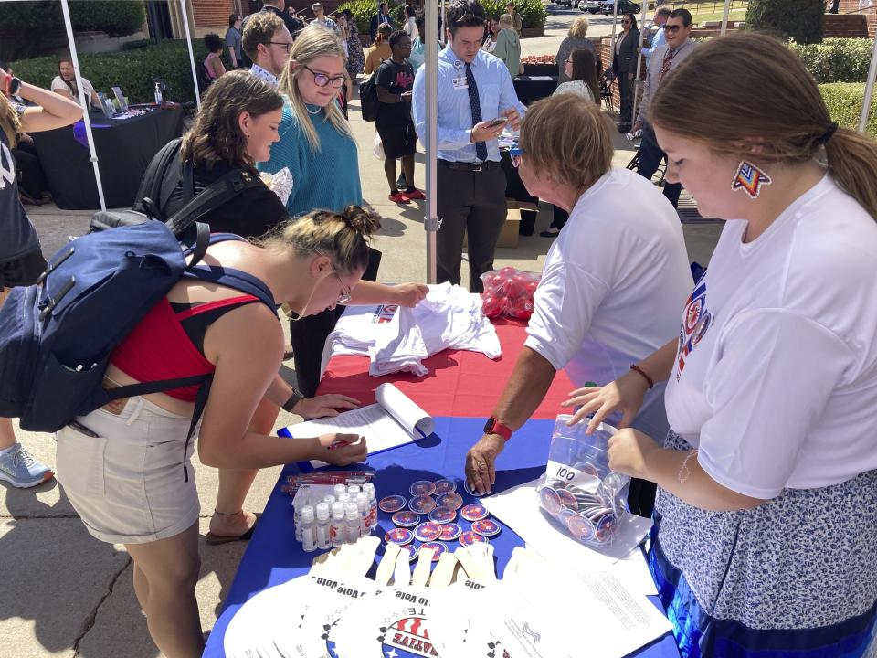 Devon Rain Potter, 19, right, a citizen of the Chickasaw Nation, helps students register to vote at East Central University in Ada, Oklahoma, on Sept. 20, 2022. (AP Photo by Sean Murphy)