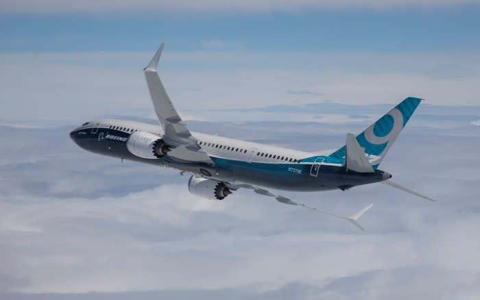 A Boeing 737 MAX 9 flying over clouds