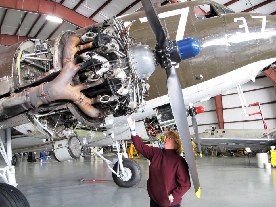 This photo taken March 6, 2014, shows pilot Naomi Wadsworth with a World War II-era Douglas C-47, housed at the National Warplane Museum in Geneseo, N.Y. At the invitation of the French government, the airplane will return to France in June to participate in celebrations marking the 70th anniversary of the D-Day invasion of Normandy. The airplane, known as Whiskey 7 because of its markings, is one of the original troop carriers that dropped paratroopers in advance of the amphibious invasion. In June it will recreate its role and drop paratroopers over the original drop zone in Sainte-Mere-Eglise. (AP Photo/Carolyn Thompson)