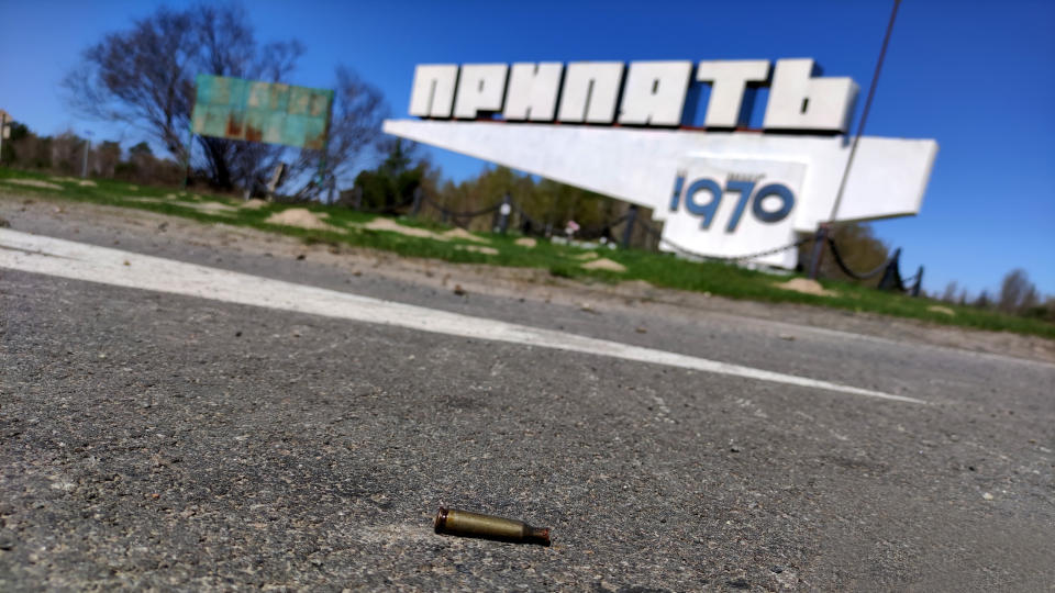 A spent bullet cartridge lies on the asphalt near the sign that marks the limits of the ghost town of Prypiat. The area was the scene of intense fighting during the first days of Russia's invasion of Ukraine.