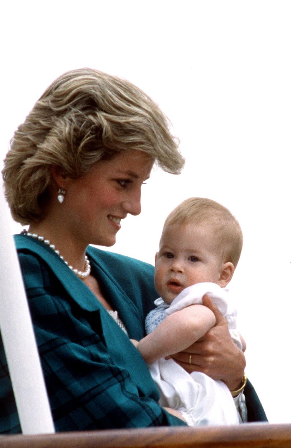 <p>Harry, 8 months, is cradled by Princess Diana aboard The Royal Yacht Britannia during an official tour of Italy. In the 2017 HBO documentary, <em>Diana, Our Mother: Her Life and Legacy</em>, Harry said of his mother, "She would just engulf you and squeeze you as tight as possible. And being as short as I was then, there was no escape; you were there and you were there for as long as she wanted to hold you."</p>