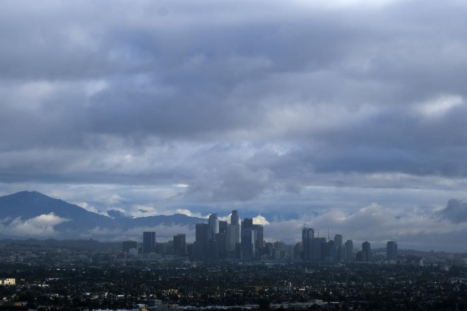 Storm clouds blanket the Los Angeles skyline is seen from Kenneth Hahn State Recreation Area on Friday, Dec. 24, 2021. Forecasters issued a flood watch for areas east and southeast of Los Angeles starting Thursday evening because of possible heavy overnight rain fed by an atmospheric river, a long plume of moisture from the Pacific Ocean. (AP Photo/Ringo H.W. Chiu)