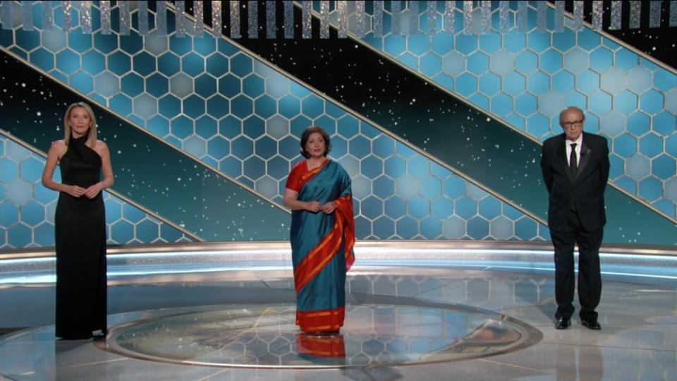 Three members of the Hollywood Foreign Press Assn. take the stage at the Golden Globes ceremony.