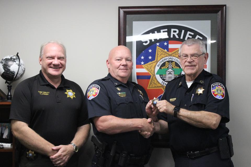 Rutherford County Sheriff Mike Fitzhugh, far right, hands RCSO Major Steve Spence his new badge as Deputy Chief of Support Services. At left is Chief Deputy Keith Lowery.