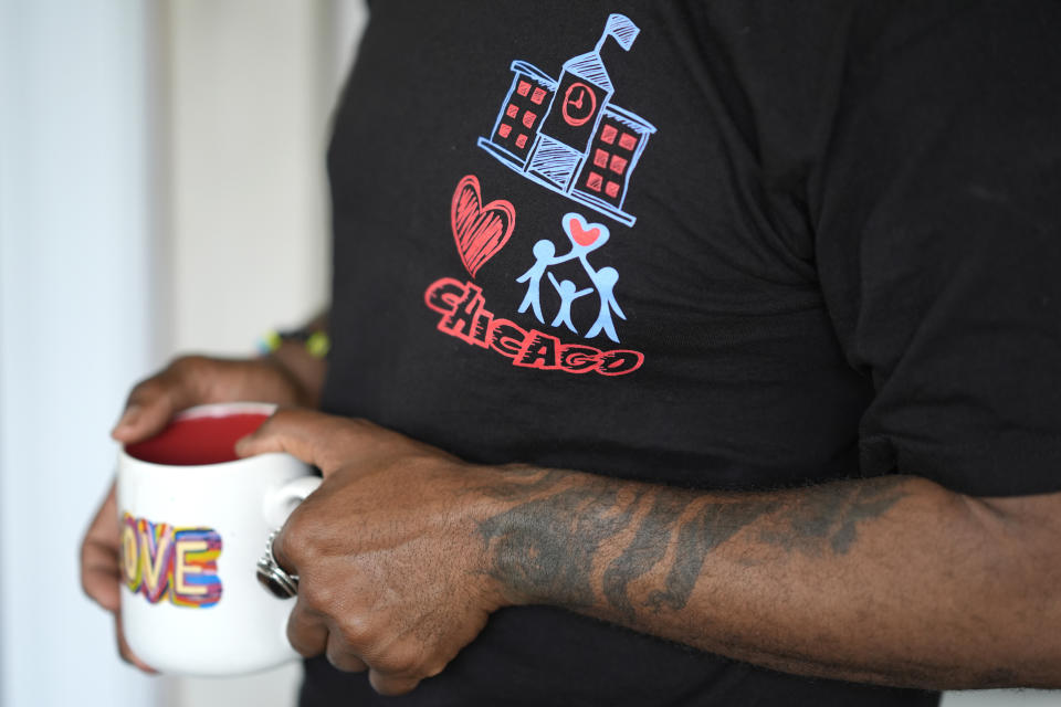 Chicago School Board candidate, rapper Che "Rhymefest" Smith, sports a campaign t-shirt after an interview with The Associated Press, at his home in the Chatham neighborhood of Chicago, Tuesday, May 21, 2024. The nation's third-largest city is preparing for its first-ever school board elections and the slate of potential candidates include progressive activists, an afterschool squash program leader and a Grammy-winning rapper. (AP Photo/Charles Rex Arbogast)