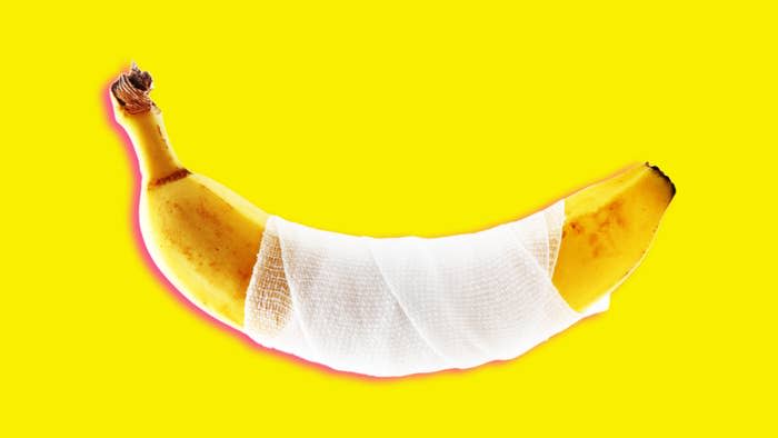 A banana wrapped partially in a white bandage is displayed against a plain background