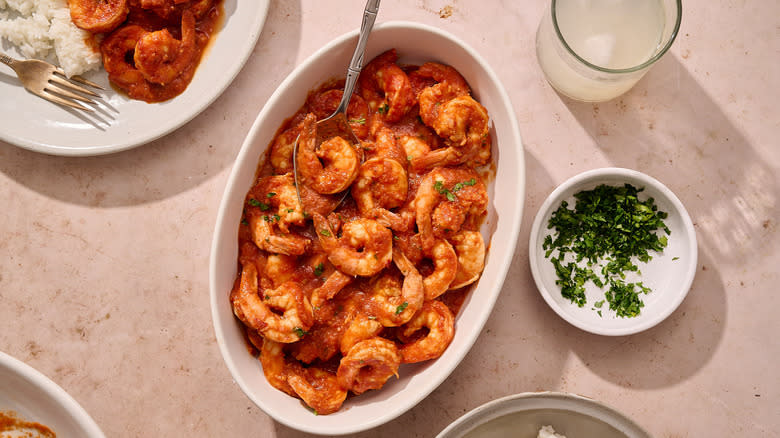 sprinkling cilantro on shrimp in bowl