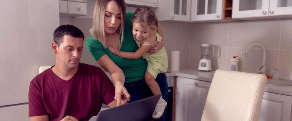 Worried young parent calculating bills at home