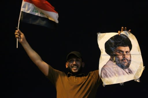 An Iraqi man celebrates with a picture of Shiite cleric Muqtada Sadr during the general election in Baghdad on May 14, 2018