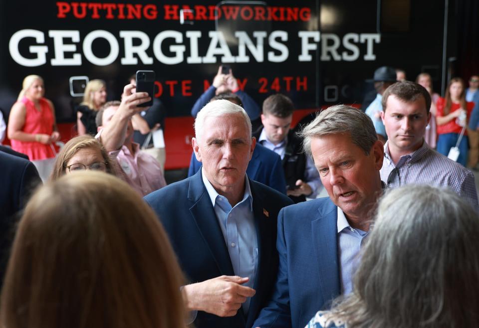 Former US Vice President Mike Pence (center) and Georgia Gov. Brian Kemp (right) speak with rallygoers at a primary eve event in Kennesaw, Georgia on May 23.