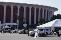 People wait inside their vehicles in line at a mass COVID-19 vaccination site outside The Forum in Inglewood, Calif., Tuesday, Jan. 19, 2021. (AP Photo/Damian Dovarganes)