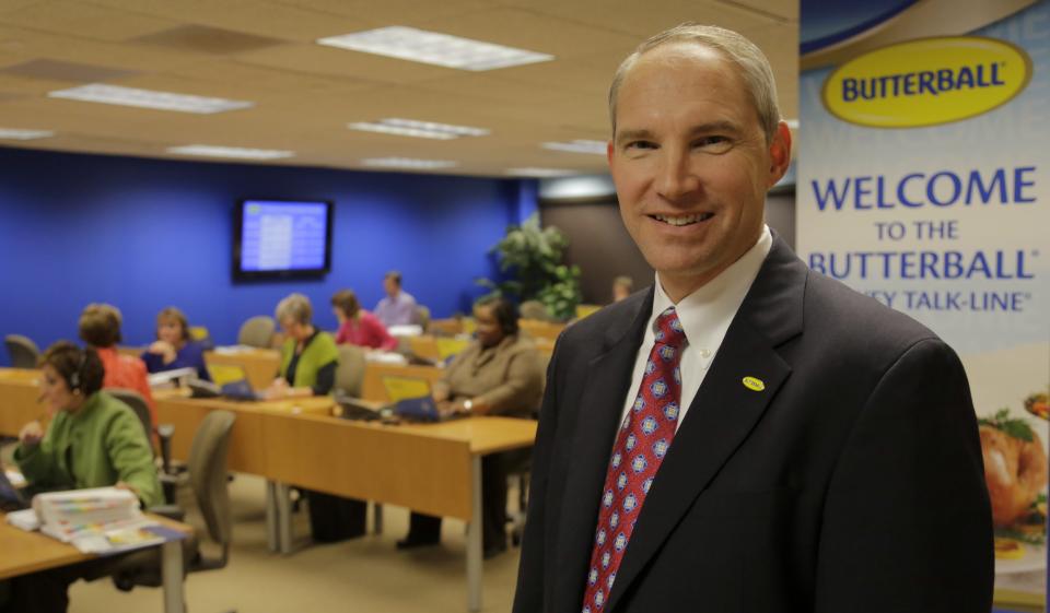 This Nov. 22, 2013 photo shows Butterball Turkey CEO Rod Brenneman posing in front of a group of Turkey Talk-Line experts at work, in Naperville, Ill. (AP Photo/M. Spencer Green)