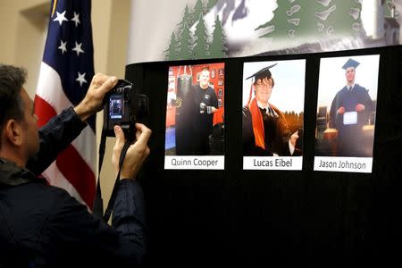 A photographer takes a picture of photos of Umpqua Community College shooting victims at a media conference in Roseburg, Oregon, United States, October 3, 2015. REUTERS/Lucy Nicholson