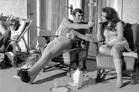 <p>George Lazenby offers co-star Helena Ronee a light, while filming <em>On Her Majesty's Secret Service.</em></p>