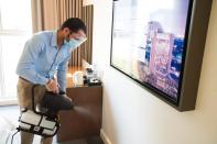 In this Monday, July 6, 2020 photograph, an employee wearing a mask due to the coronavirus pandemic fogs disinfectant in a hotel room at the Rove City Centre Hotel in Dubai, United Arab Emirates. Dubai reopened for tourists Tuesday, July 7, 2020, amid the coronavirus pandemic, hoping to reinvigorate a vital industry for this city-state before its crucial winter tourist season. (AP Photo/Jon Gambrell)