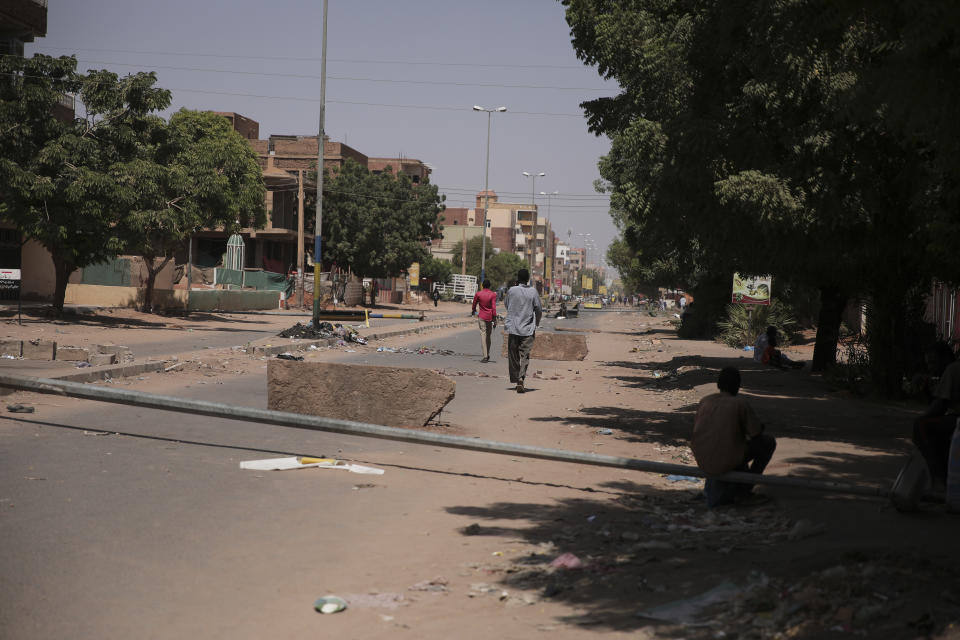 People walk on a street in Khartoum, Sudan, two days after a military coup, Wednesday, Oct. 27, 2021. The coup threatens to halt Sudan's fitful transition to democracy, which began after the 2019 ouster of long-time ruler Omar al-Bashir and his Islamist government in a popular uprising. It came after weeks of mounting tensions between military and civilian leaders over the course and pace of that process. (AP Photo/Marwan Ali)