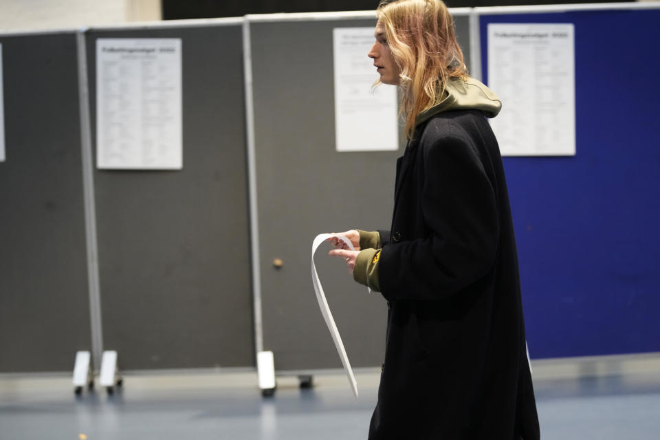 A man walks with a ballot before casting at a polling station in Copenhagen, Denmark, on Tuesday, Nov 1, 2022. Denmark's election on Tuesday is expected to change its political landscape, with new parties hoping to enter parliament and others seeing their support dwindle. A former prime minister who left his party to create a new one this year could end up as a kingmaker, with his votes being needed to form a new government. (AP Photo/Sergei Grits)