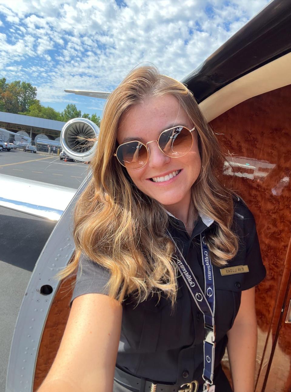 Female pilot taking a selfie on a private jet.