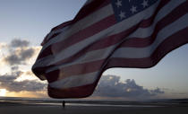 A man in a vintage US WWII uniform walks at sunrise prior to a D-Day 76th anniversary ceremony in Saint Laurent sur Mer, Normandy, France, Saturday, June 6, 2020. Due to coronavirus measures many ceremonies and memorials have been cancelled in the region with the exception of very small gatherings. (AP Photo/Virginia Mayo)