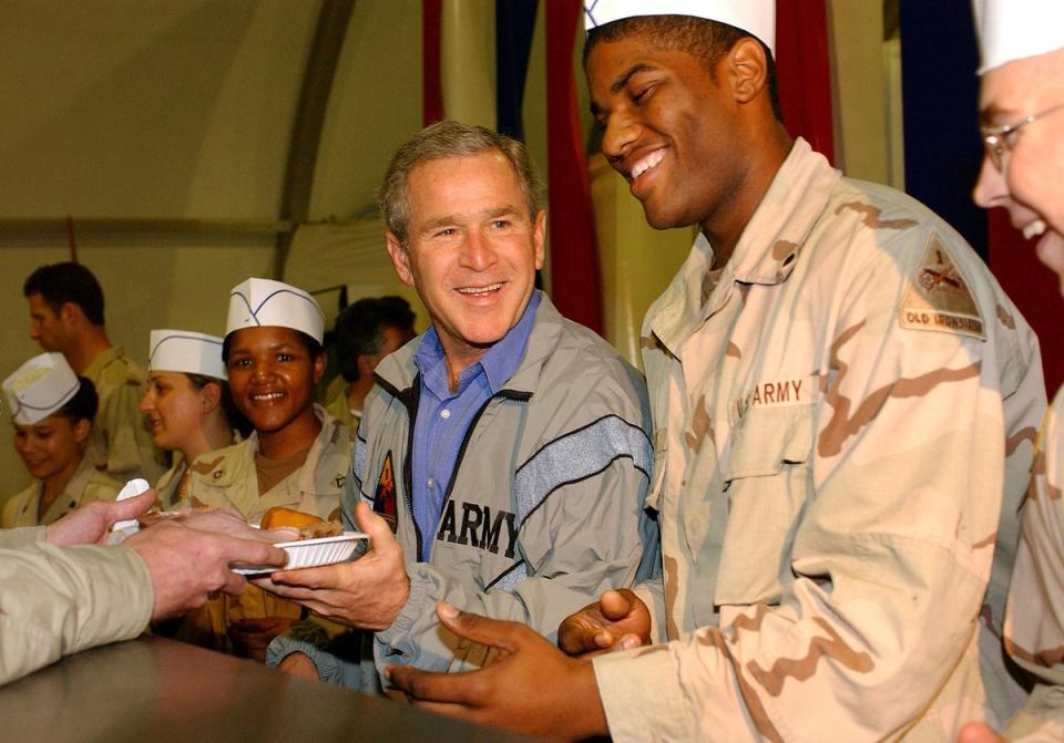 George W Bush paid a visit to US troops in Iraq in 2003 – one of many visits made by US presidents to war zones (Getty Images)