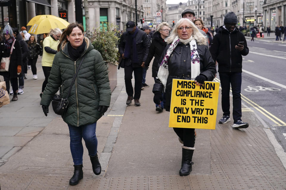 People hold placards as they attend an anti vaccines protest, in London, Saturday, Jan. 22, 2022.(AP Photo/Alberto Pezzali)