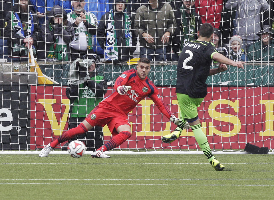 Seattle Sounders midfielder Clint Dempsey, right, scores on a penalty kick to tie the game against Portland Timbers goalkeeper Andrew Weber late in the second half of an MLS soccer game in Portland, Ore., Saturday, April 5, 2014. The two teams tied 4-4. (AP Photo/Don Ryan)