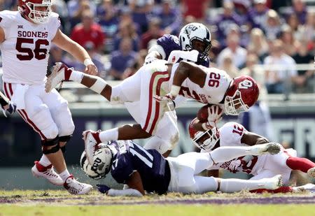 Oct 20, 2018; Fort Worth, TX, USA; Oklahoma Sooners running back Kennedy Brooks (26) jumps over TCU Horned Frogs safety Trevon Moehrig-Woodard (17) during the second half at Amon G. Carter Stadium. Mandatory Credit: Kevin Jairaj-USA TODAY Sports