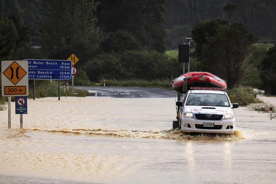 An emergency vehicle carries a inflatable boat across a flooded road at Cook's Beach, east of Auckland, New Zealand, Tuesday, Feb. 14, 2023. The New Zealand government declared a state of emergency across the country's North Island, which has been battered by Cyclone Gabrielle. (Mike Scott/New Zealand Herald via AP)