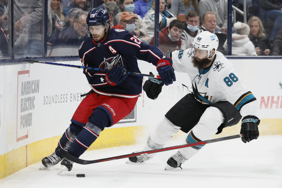 Columbus Blue Jackets' Oliver Bjorkstrand, left, and San Jose Sharks' Brent Burns chase the puck during the second period of an NHL hockey game Sunday, Dec. 5, 2021, in Columbus, Ohio. (AP Photo/Jay LaPrete)