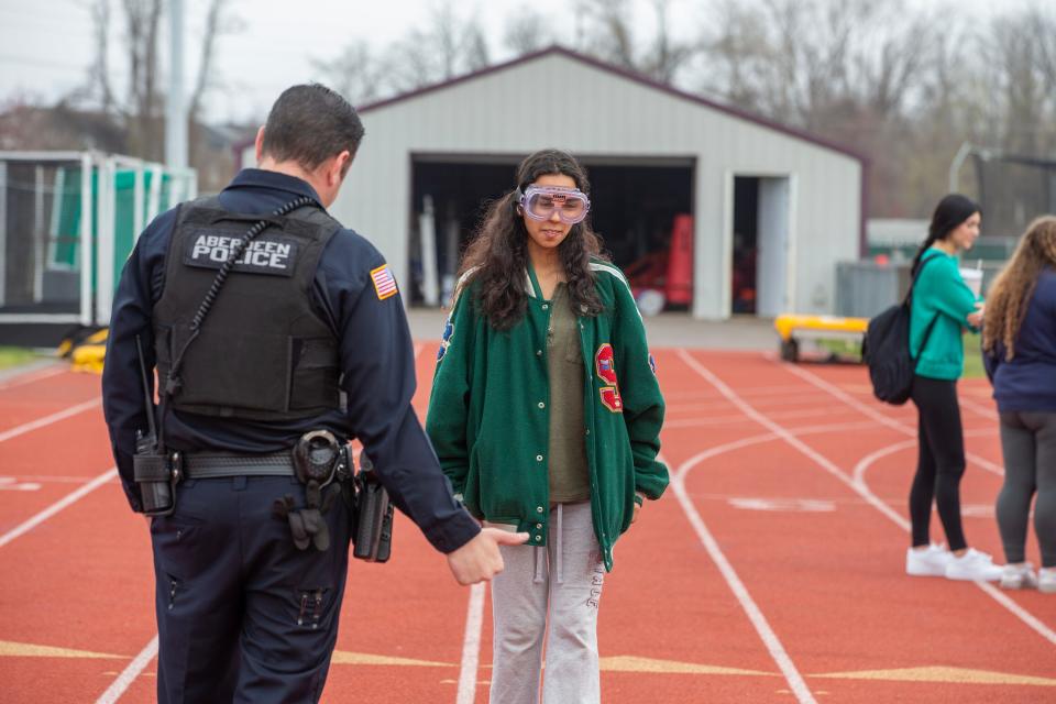 Lillian Wiley, 17, of Matawan wears impairment googles as she participates in a walk and turn DUI field sobriety exercise with Aberdeen Twp. Police Officer Evan Guastaferro during Road Safety Day at Matawan Regional High School in Aberdeen Twp., NJ Thursday, April 11, 2024.