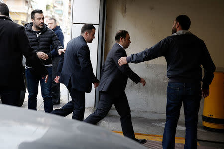 Two of the eight Turkish soldiers, who fled to Greece in a helicopter and requested political asylum after a failed military coup against the government, are escorted by police officers as they arrive at the appeals court in Athens, Greece, March 16, 2018. REUTERS/Costas Baltas