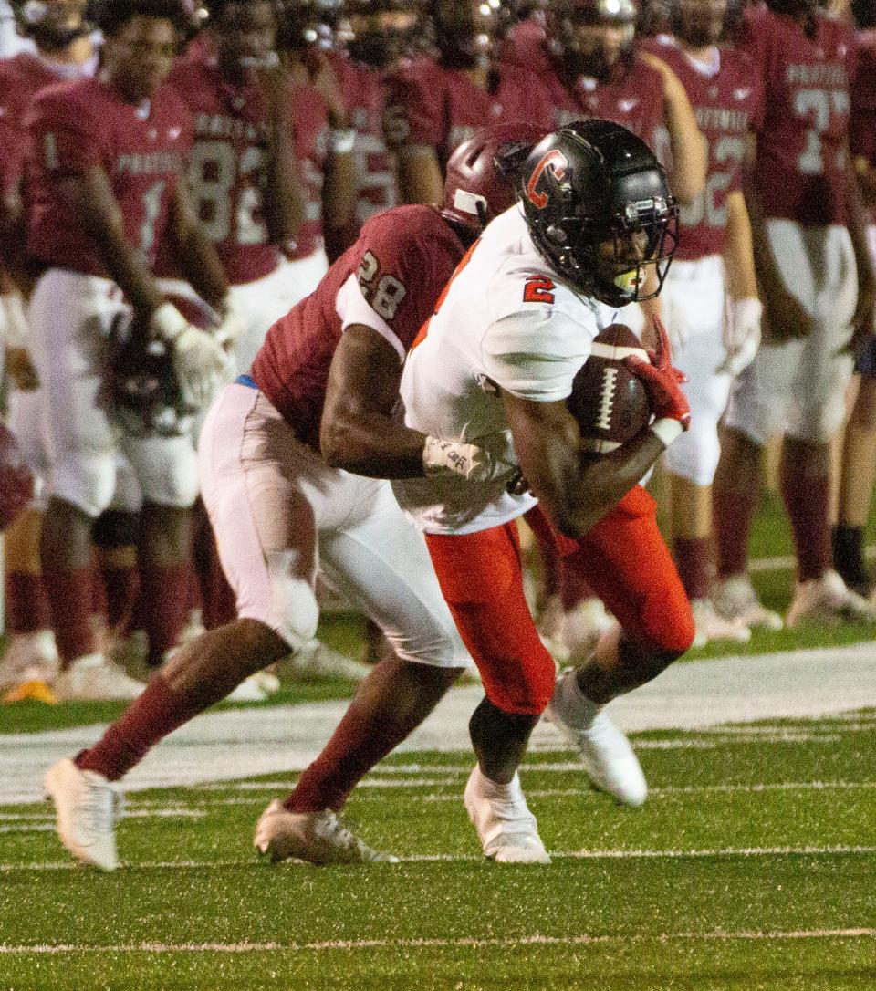 Central-Phenix City's Karmello English (2) snags a pass in the first quarter as Prattville's AP Coleman (28) tries to drag him down for a tackle.